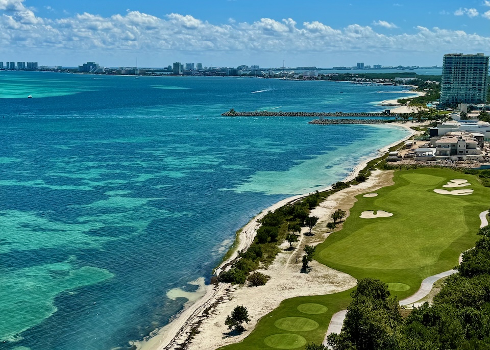 View over the ocean and a golf course toward the Cancun hotel zone at Puerto Juarez.