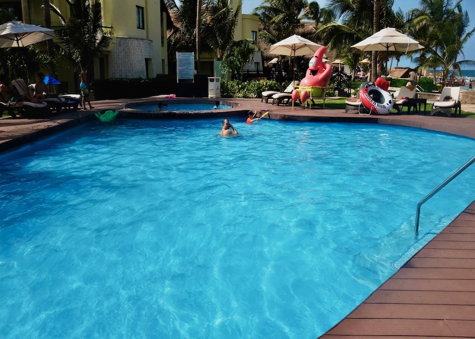 A family in the pool and a statue of Patrick from Spongebob at Azul Beach Resort in Cancun.