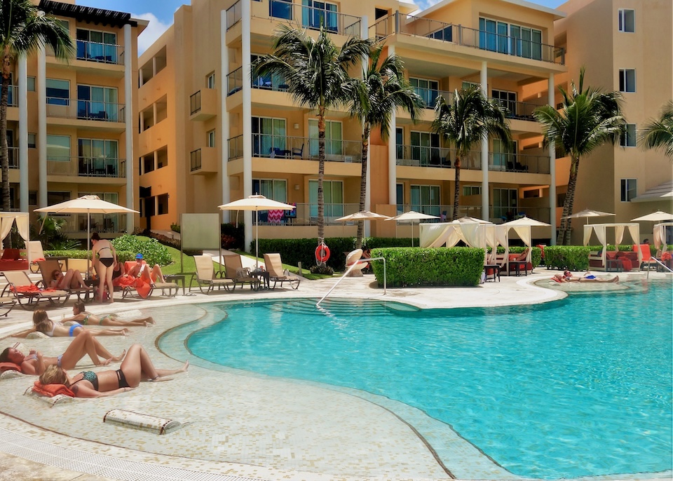 People reclining in the partially submerged sunbed section next to the main pool at Dreams Jade resort in Cancun.