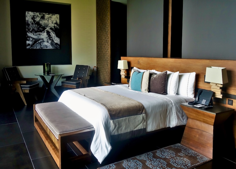 A stylish room in warm woods, black accents, and a splash of turquoise at Nizuc resort in Cancun.