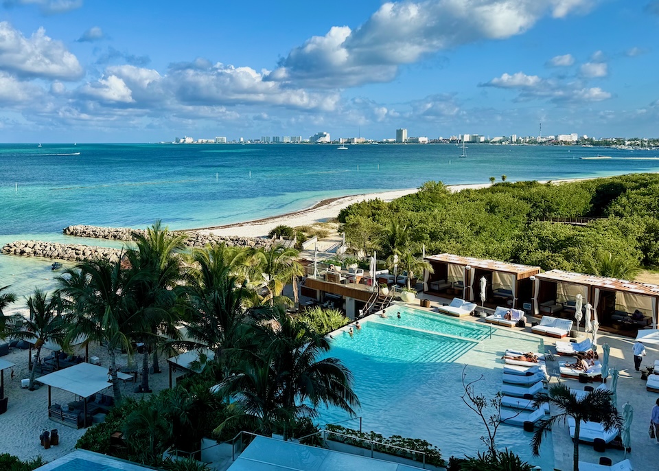 An infinity pool above the beach with a view toward the Cancun Hotel Zone at SLS hotel in Puerto Juarez, Cancun.