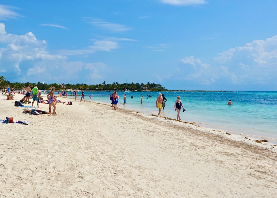 People swimming, wading, and sunbathing on Akumal Beach north of Tulum in the Riviera Maya.