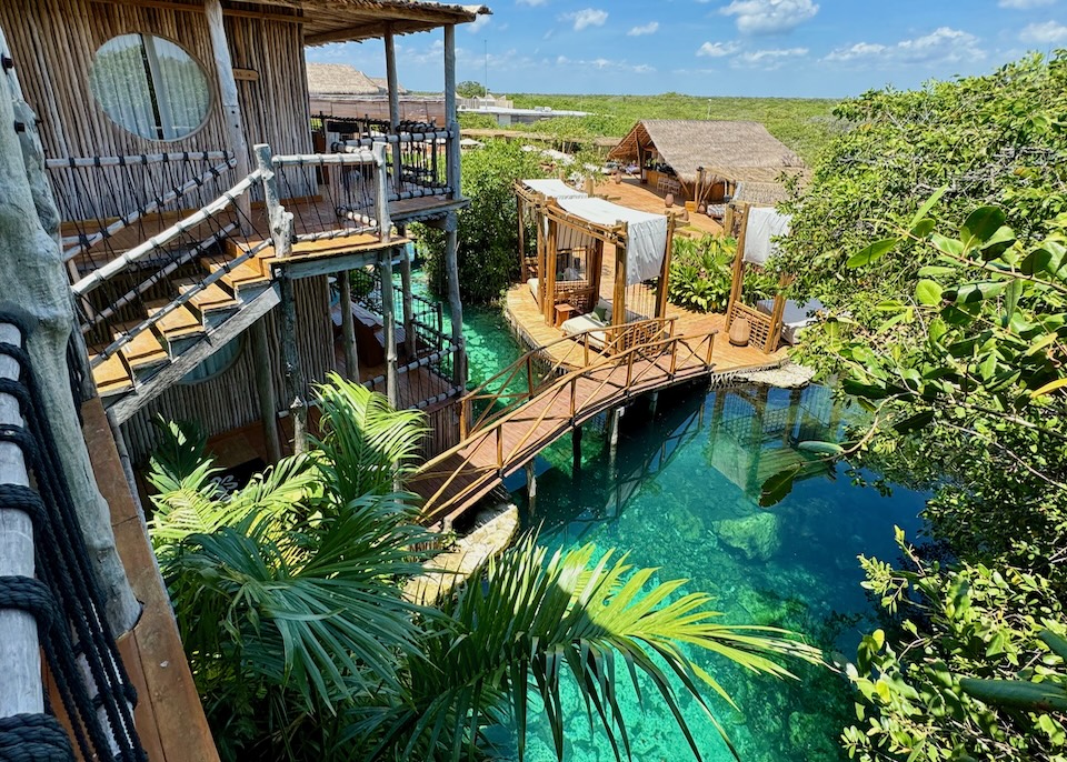 Rustic wooden buildings on platforms above a cenote at Shibari hotel in the Middle Beach Zone of Tulum.