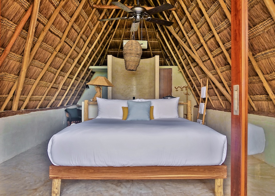 An A-freame bedroom wth a thatched roof at La Valise hotel in the South Beach Zone of Tulum.