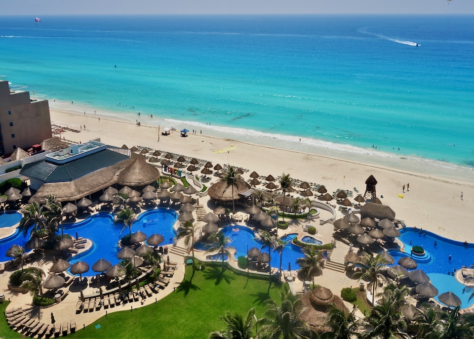 A series of freeform pools fronted by a long, wide stretch of beach at the JW Marriott resort in the Middle Hotel Zone of Cancun.