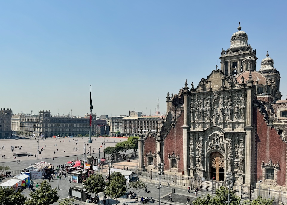 The ornate Mexican Baroque façade of the Metropolitan Cathedral with the Zócalo in the background in the Centro Histórico neighborhood of Mexico City.