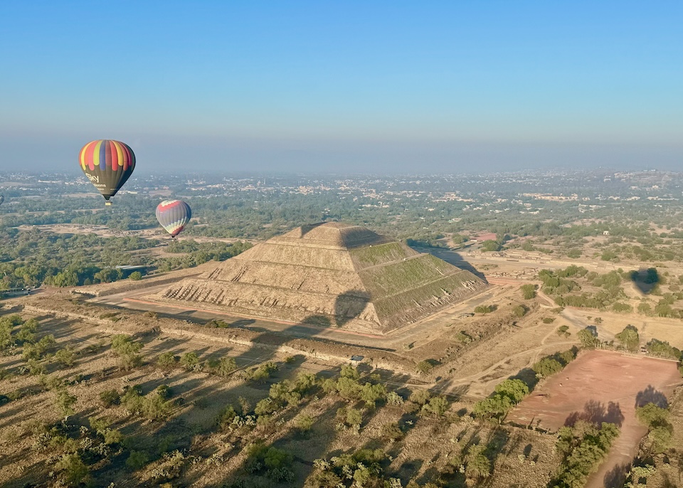 Two hot air balloons floating above one of the pyramids of Teotihuacan just outside Mexico City.