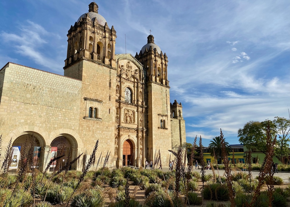 The landmark Mexican Baroque church of Santo Domingo de Guzmán with it's two domed towers, ornate façade, and stone walls in the Santo Domingo neighborhood of Oaxaca.