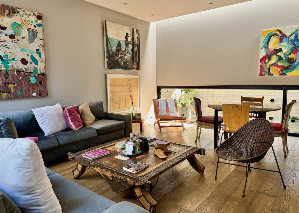 The art-filled living room with a mix of antique and contemporary furniture in a room at El Callejon Boutique Hotel in Oaxaca.