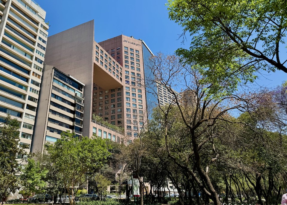 The recently renovated high-rise JW Marriott Hotel built in the 1980s as seen from a verdant public park in Mexico City.