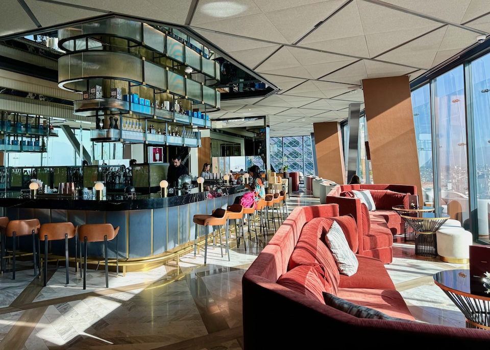 A retro-chic bar on the highest floor of the Ritz-Carlton hotel with velvet sofas, marble floors, brass accents, and floor-to-ceiling windows with views of Mexico City.